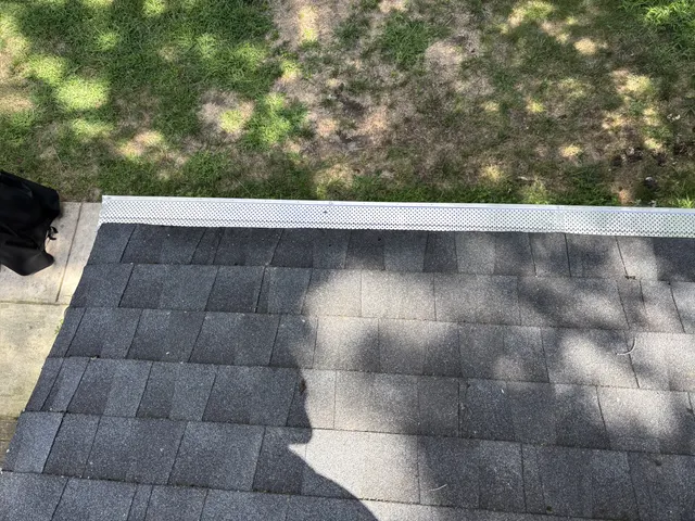 Perforated gutter guard installed along a completed Gibbsboro roof edge