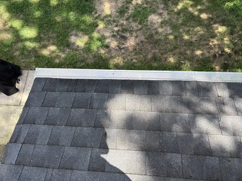 Perforated gutter guard installed along a completed Gibbsboro roof edge