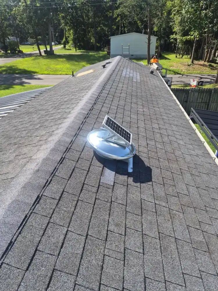 Solar-powered attic fan mounted on a shingle roof
