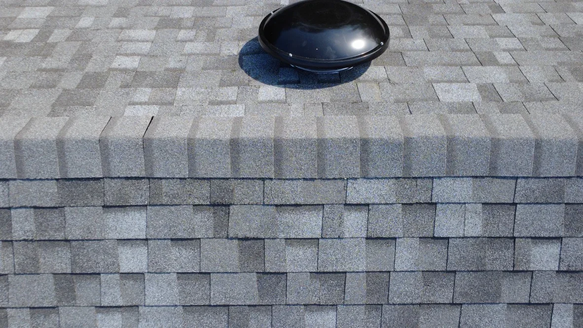 Installed gray shingles and roof vent