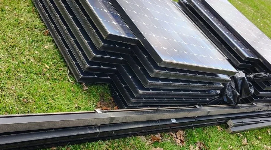 Removed solar panels at ground level with long rail sections beside them in Pine Hill, New Jersey